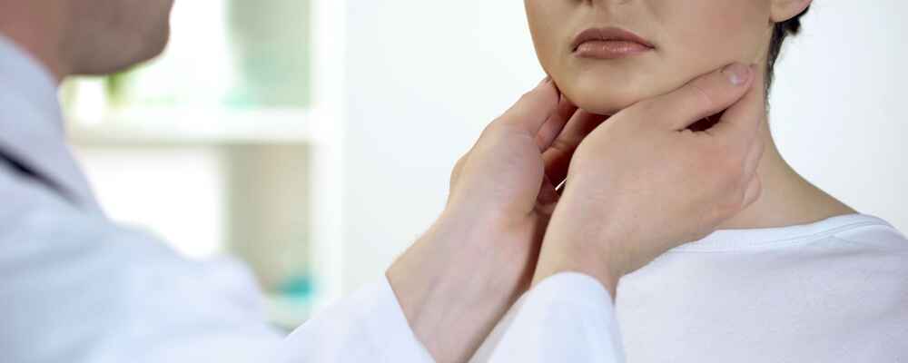 ENT doctor doing a thyroid check on patient