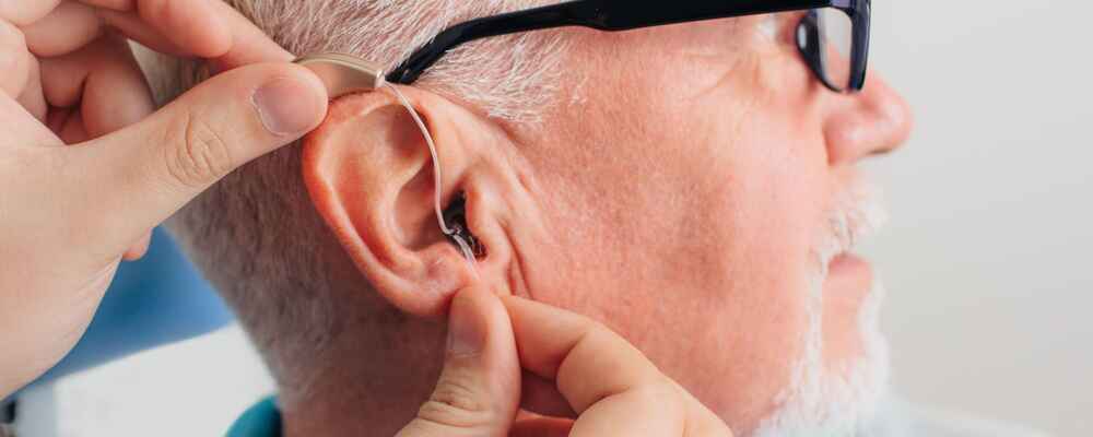 Audiologist helping with hearing aid fitting for patient