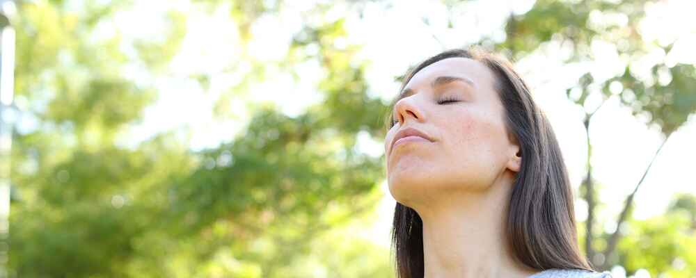 Woman breathing and enjoying nature while being free of allergies